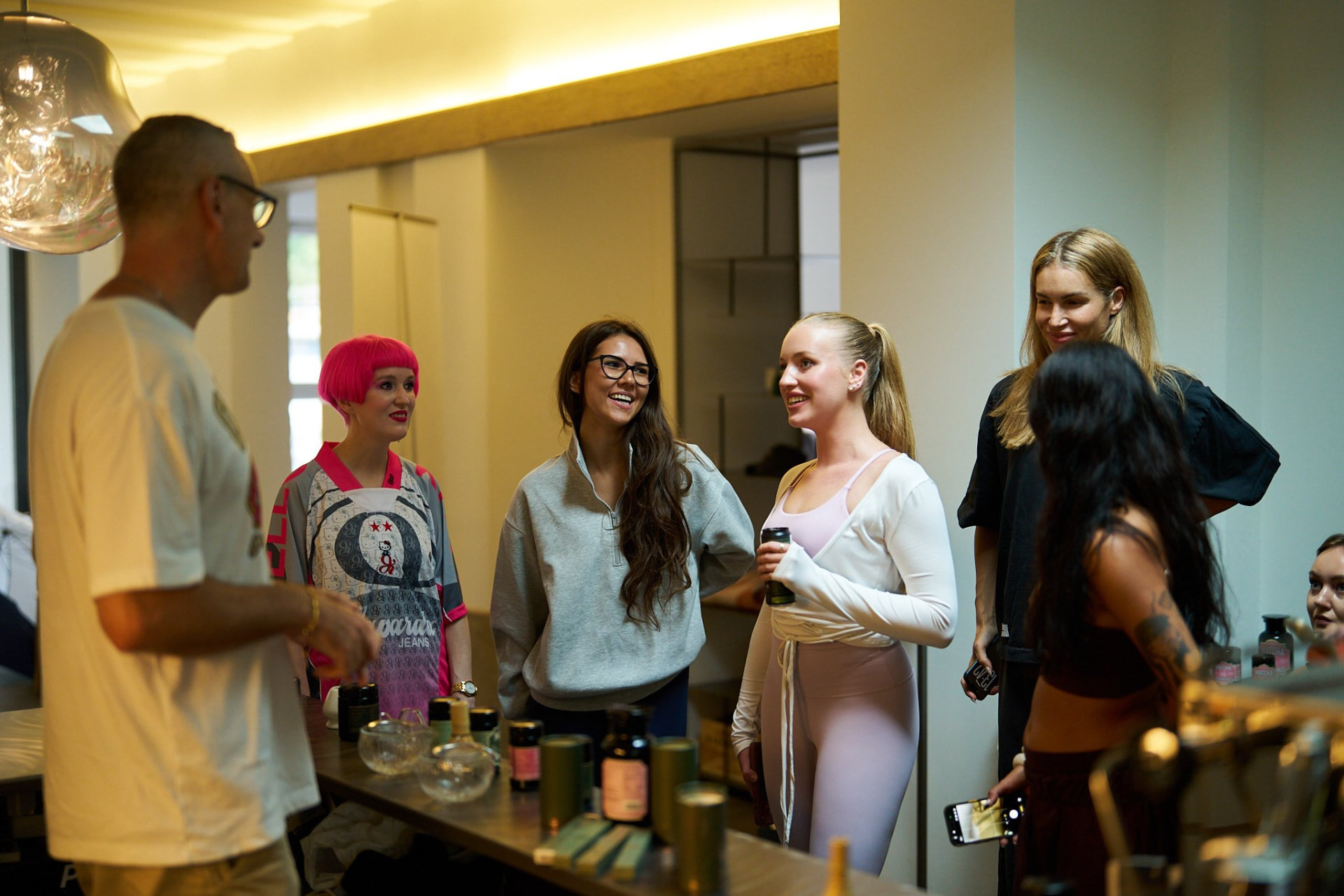 Guests gathered at the wooden bar at Claw Studio during a Matcha Botanicals tasting, with tasting bowls, tins and cans on the counter