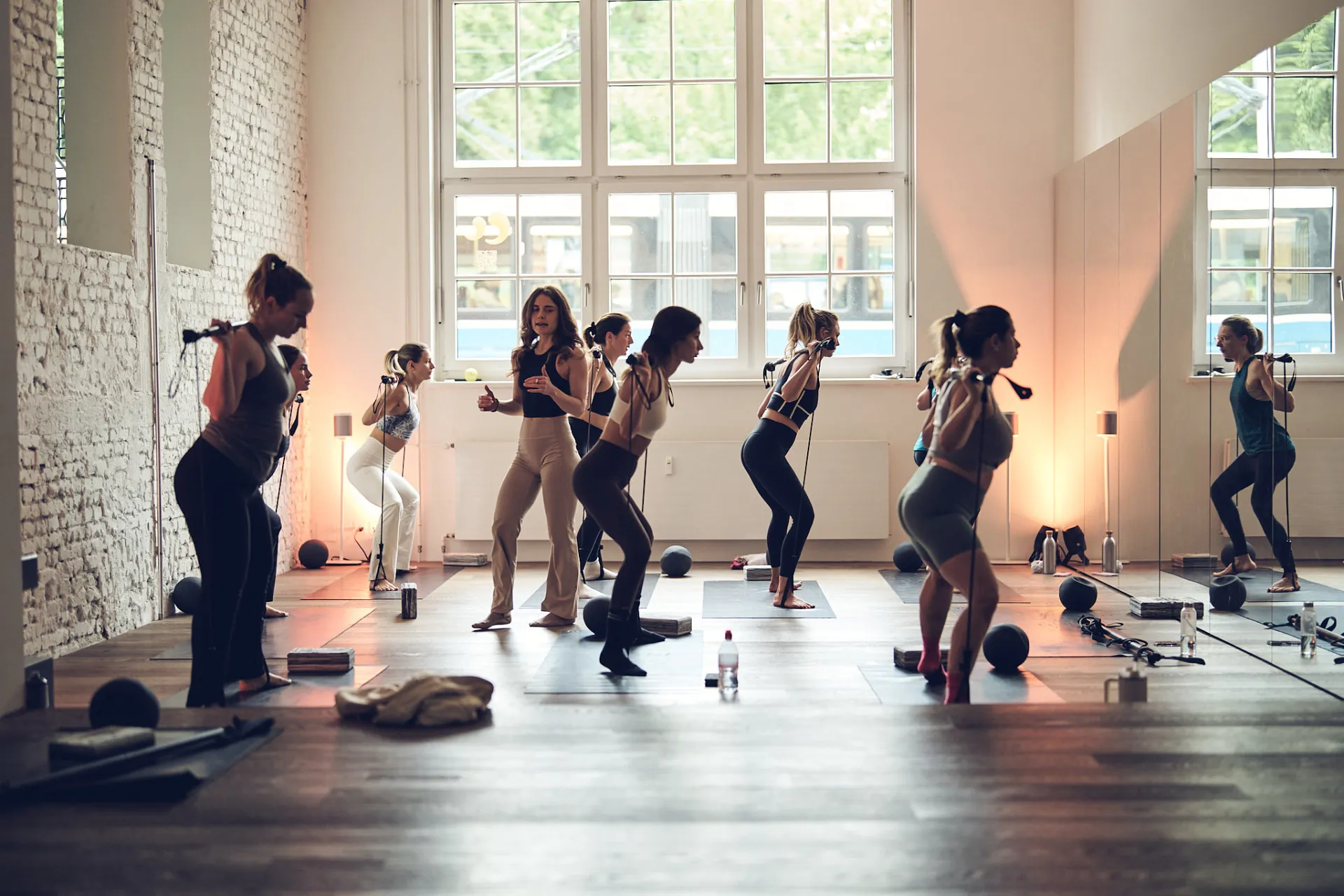 Coaches leading a sculpt class with resistance bands in Claw Studio